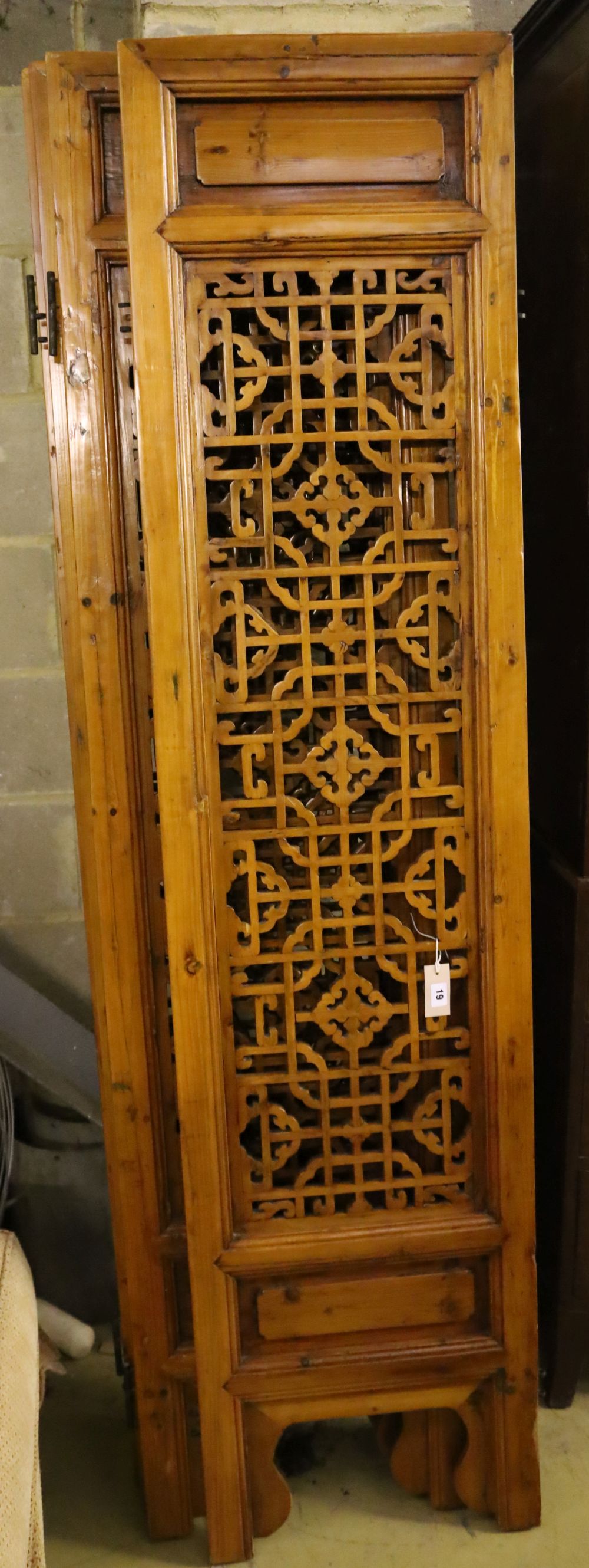 A Chinese carved and pierced pine four-fold screen, each panel width 47cm, height 198cm